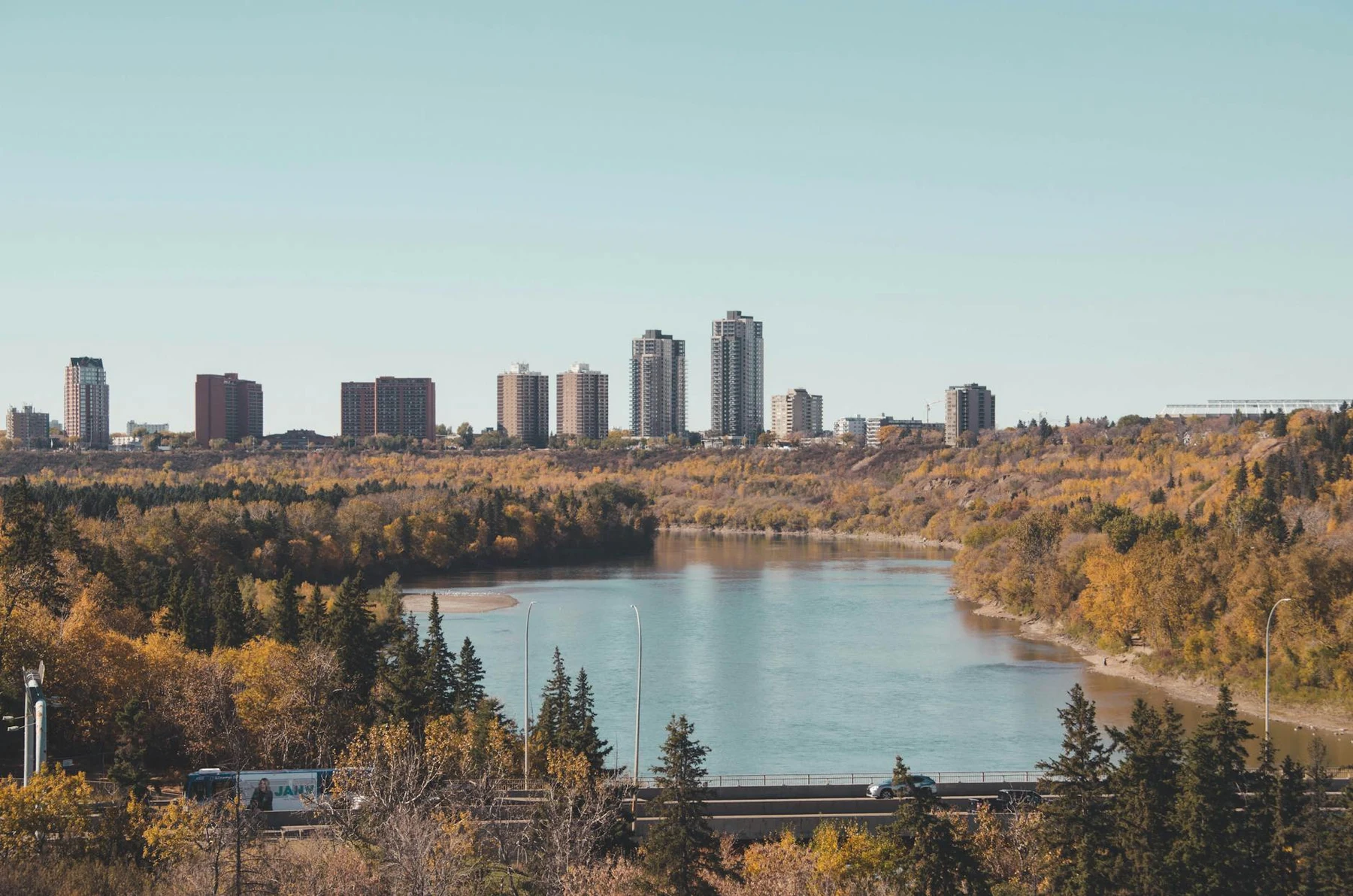Breathtaking cityscape with a river and fall foliage, perfect autumn travel destination.