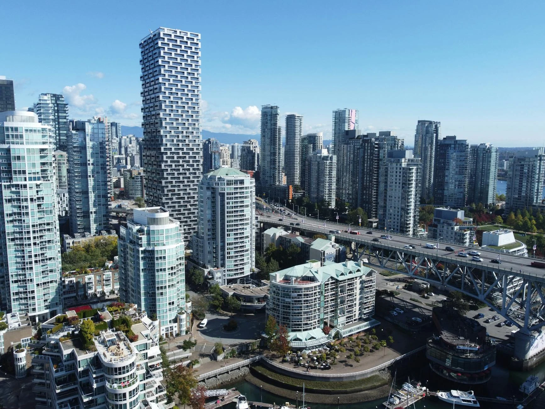 A stunning aerial view of Vancouver's skyline during daytime, showcasing modern architecture and bustling city life.
